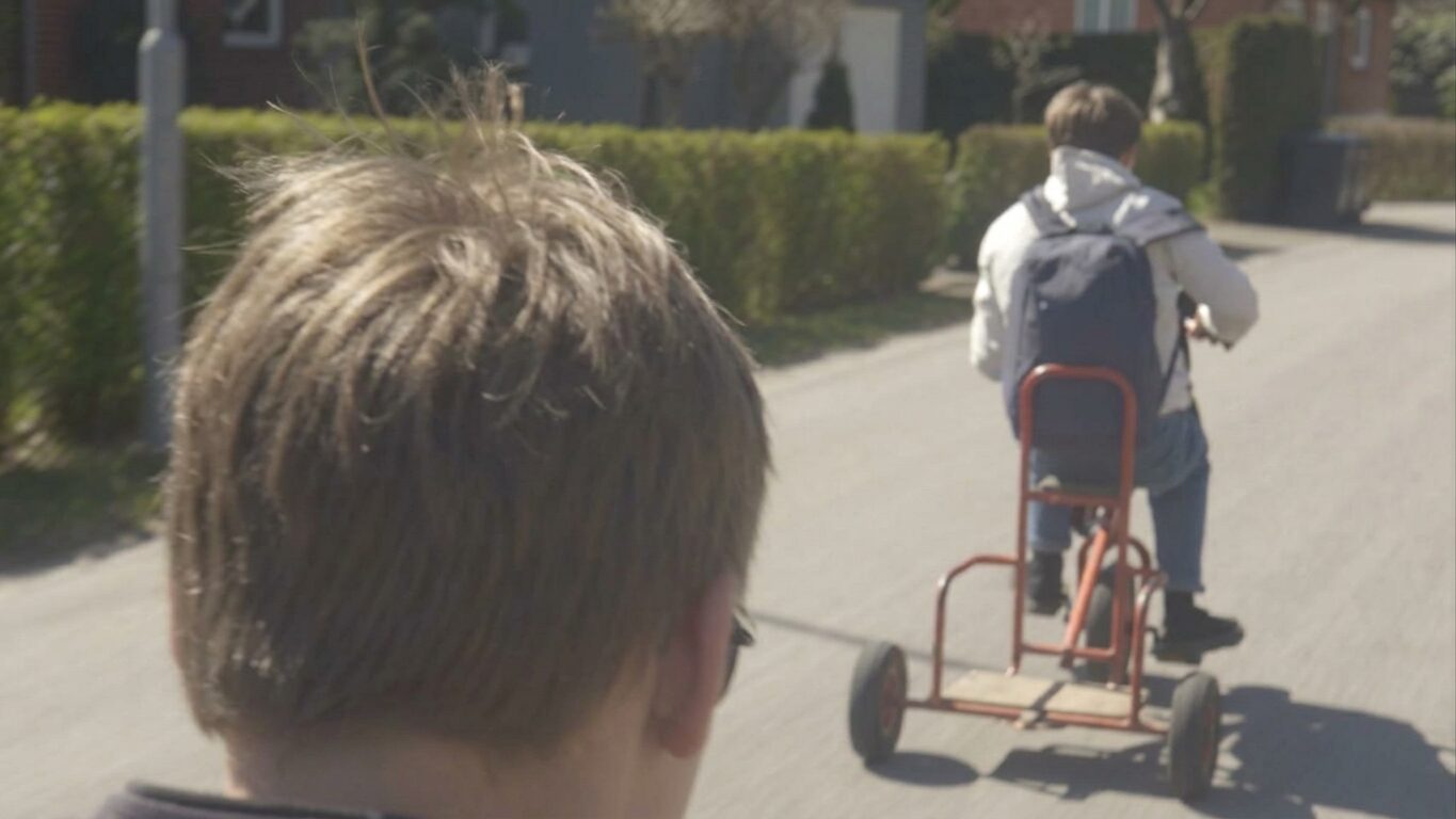 Stillbild ur Jonathan I. Jakten på trehjulingen genom villakvarteret